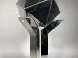 sculpture en argent représentant un diamant posé sur un socle noir, sur fond blanc