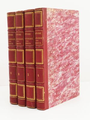trois livres rouges superposés sur une surface blanche