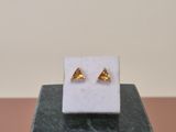 gold triangle stud earrings on a marble block