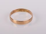 gros plan d'une bague en or sur une surface blanche