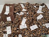 several pairs of leopard print pants are on a white surface