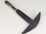 a close up of a knife on a white surface with a wooden handle