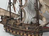a model of a ship on display on a white surface