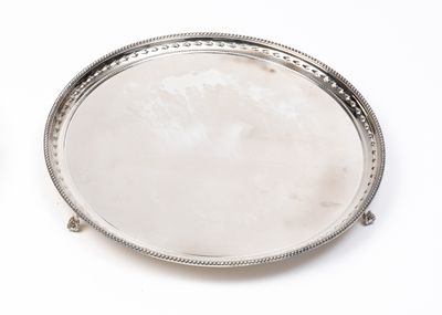 deux plateaux en argent empilés l'un sur l'autre sur une surface blanche