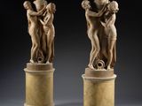 une paire de sculptures en marbre représentant une femme et un homme, posées sur des socles