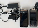 two cell phones and a charger sitting on a table