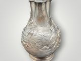 a silver vase that is sitting on a table