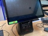 un écran d'ordinateur posé sur un bureau, avec un chargeur