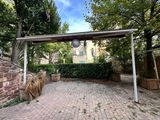 a brick walkway with a metal structure in the middle of it