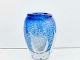 a blue vase sitting on a table with a white background