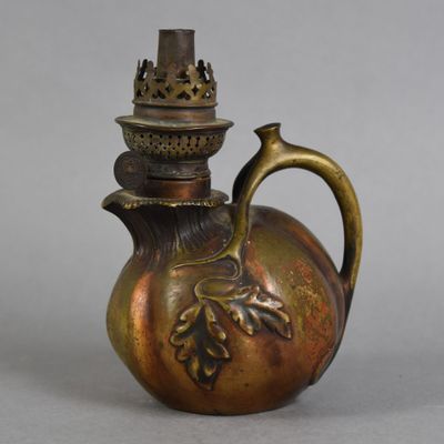 une théière en bronze surmontée d'une couronne