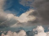 a man in a boat floating in the clouds with a full moon in the background