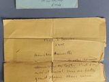 une vieille enveloppe à laquelle est joint un mot et un bout de papier sur lequel il y a quelque chose d'écrit