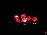 de très jolis diamants rouges posés sur une surface noire