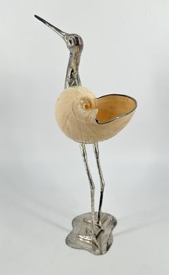 a bird that is standing on a stand with a bowl