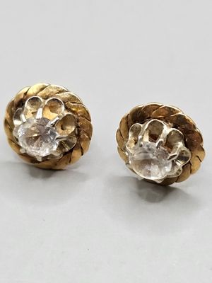two pairs of gold and diamond earrings on a white surface