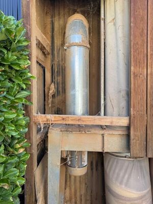 un tuyau métallique qui se trouve à l'intérieur d'une caisse en bois