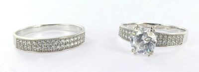 pair of engagement rings with diamonds on them on a white background