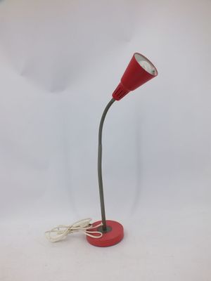 une lampe de bureau rouge surmontée d'un cordon blanc