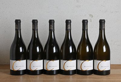 six bouteilles de vin sont alignées sur une table en bois