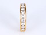 a close up view of a yellow gold wedding band with round diamonds
