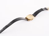 a close up of a watch on a white surface