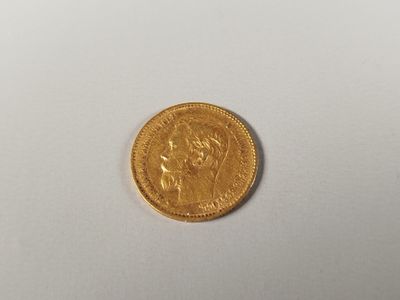 gros plan d'une pièce d'or sur une surface blanche