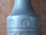 a bottle of syrup sitting on a wooden table