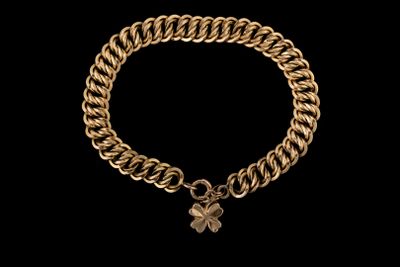 un bracelet en or orné d'une breloque en forme de trèfle
