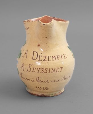a small vase with writing on it sitting on a table