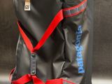 un gros plan d'un sac noir muni d'une bandoulière rouge