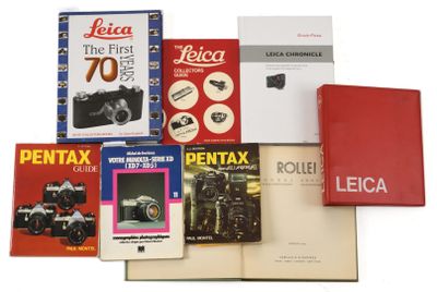 several books are stacked on top of each other on a white surface