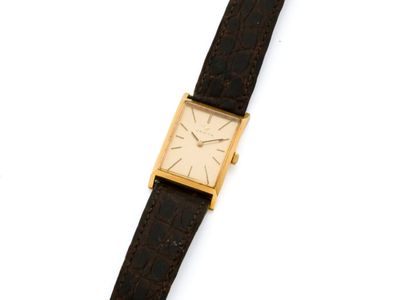 un gros plan d'une montre sur une surface blanche avec un fond blanc