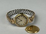 une image représentant une montre-bracelet en or et en argent ainsi qu'un bouton en or