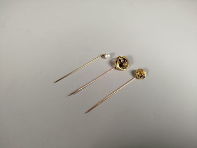 two pairs of gold earrings with pearls on them sitting on a white surface