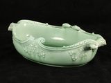 a green bowl with a handle on a black background