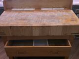 a wooden table with drawers on it in a kitchen