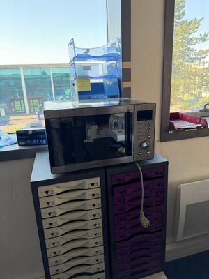 un micro-ondes posé sur un meuble près d'une fenêtre
