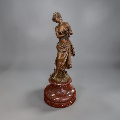 an antique bronze statue of a woman holding a child on a pedestal
