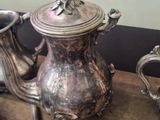 a silver tea pot sitting on a table next to other silver teapots