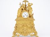 a gold clock that is sitting on top of a table