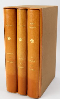 trois livres sont posés dans une boîte sur une surface blanche