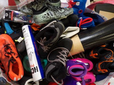 de nombreuses paires de chaussures dans un panier posé par terre