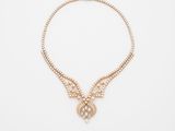 un collier en or orné de perles et d'un pendentif en forme de papillon