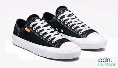 des baskets noires et blanches avec des lacets blancs sur fond blanc
