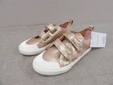 the children ' s shoes are gold and white with a white sole