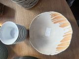 de nombreuses assiettes et tasses posées sur une table, accompagnées d'une étiquette