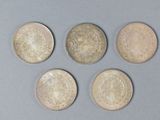 four different types of coins are shown on a gray surface