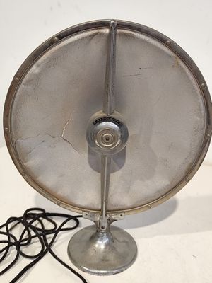 un ventilateur métallique posé sur une table