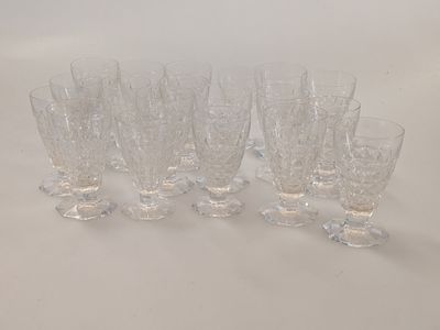 six clear glass goblets lined up on a white surface